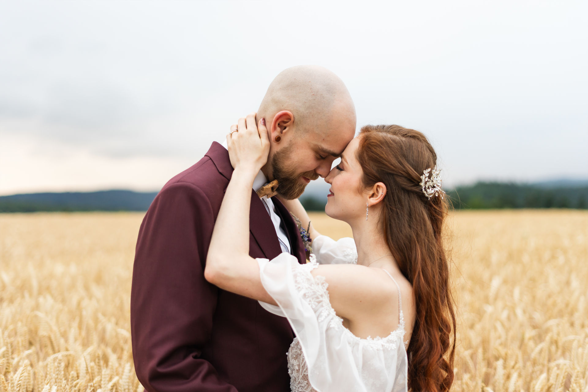 Braut und Bräutigam stehen Stirn an Stirn auf einem Feld beim Sonnenuntergang – Hochzeitsfotograf in Offenburg Jonathan Gäßler hält diesen emotionalen Moment fest.