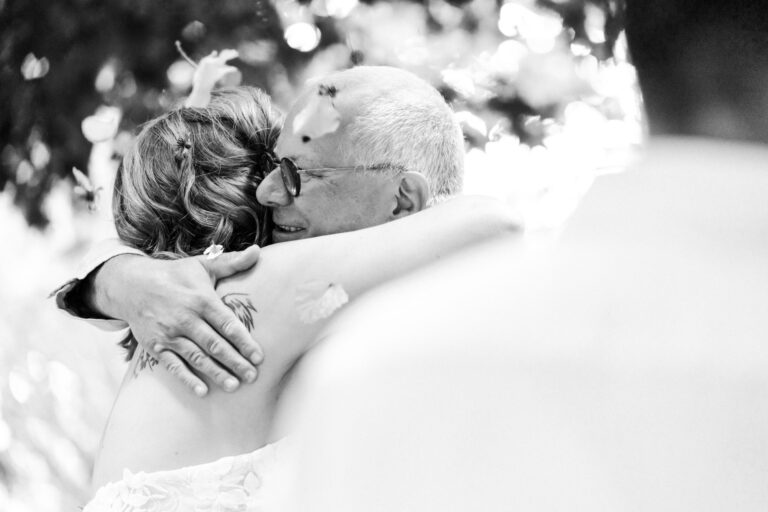 Herzliche Umarmung der Braut und eines Verwandten. Bild ist in Schwarz Weiß.