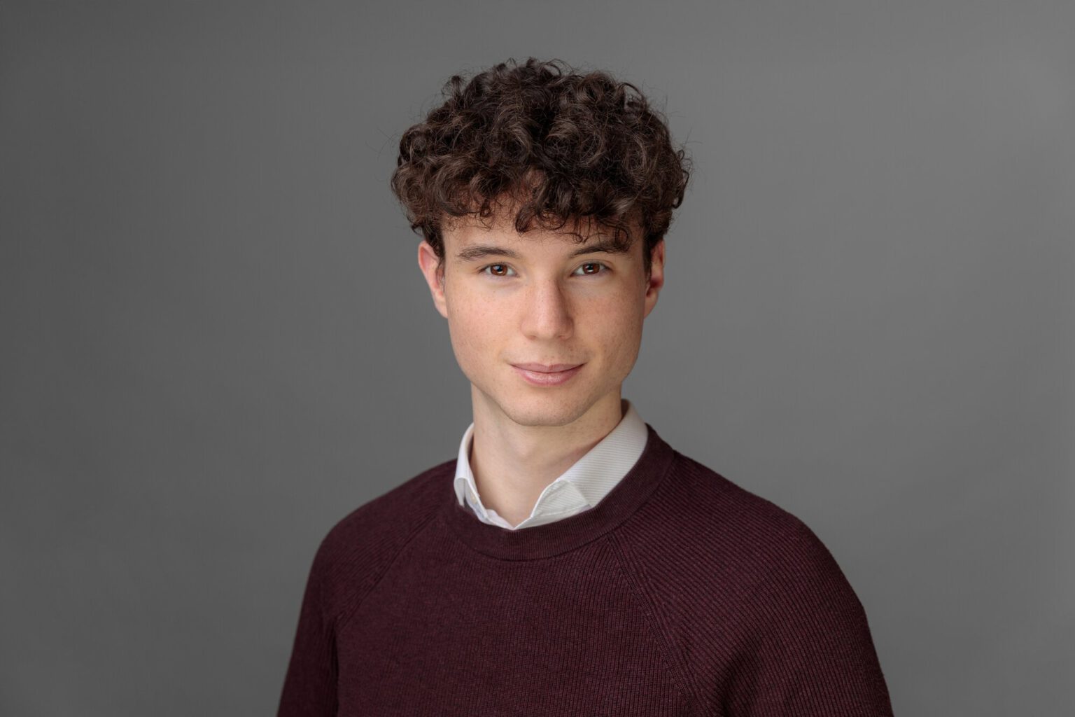 Bild von Hochzeitsfotograf Jonathan Gäßler in einem weinroten Pullover mit Hemdkragen.